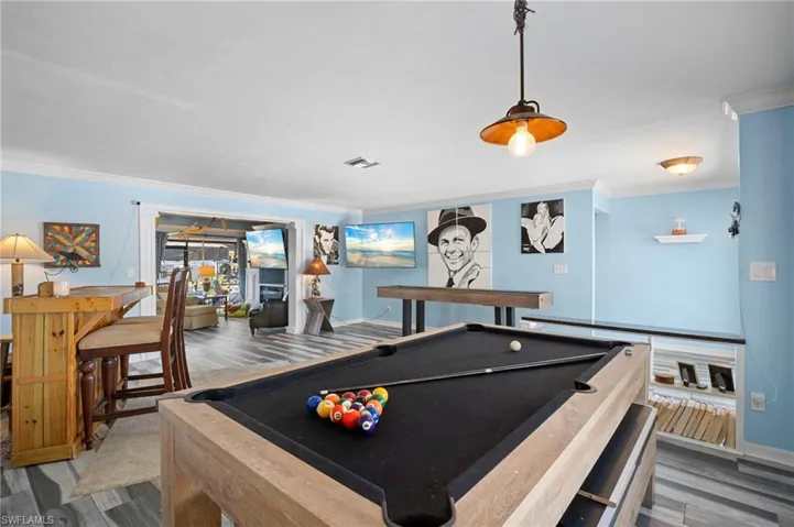 Recreation room featuring crown molding, pool table, and wood finished floors