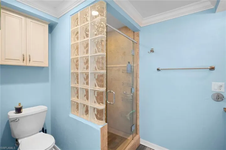 Full bath with crown molding and a stall shower