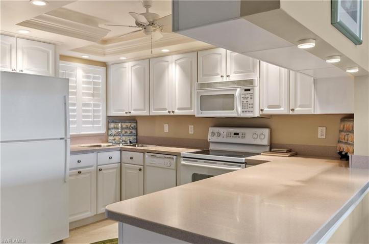 White kitchen, lots of lighting, corian counters, plantation shutters, night light.