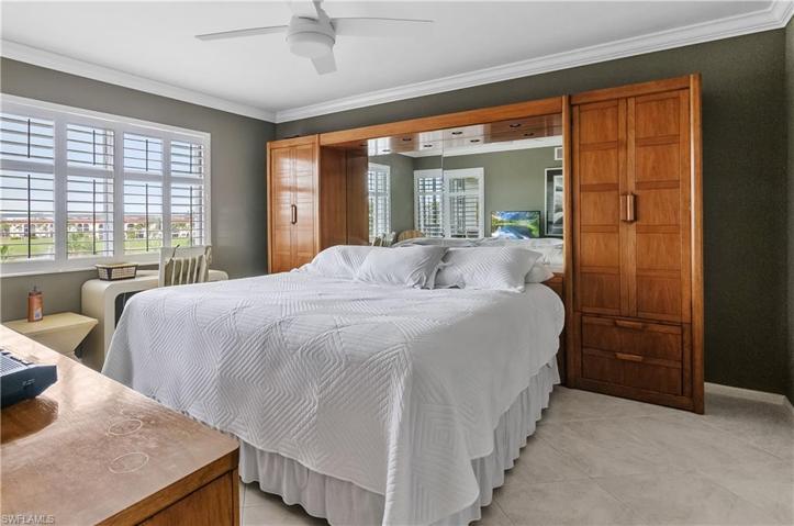 Master bedroom with extra storage, crown molding, tile floors, newer fan/light.