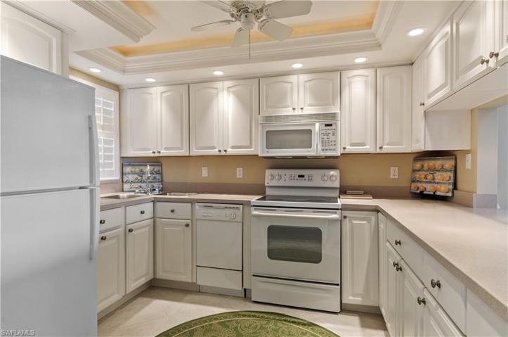 White kitchen, lots of lighting, corian counters, plantation shutters, night light.