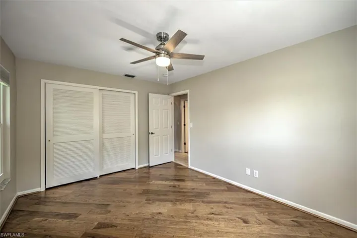 Unfurnished bedroom with ceiling fan, hardwood / wood-style floors, and a closet
