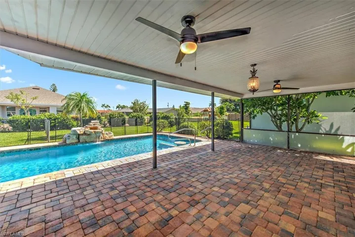 View of pool featuring pool water feature, a patio area, and ceiling fan
