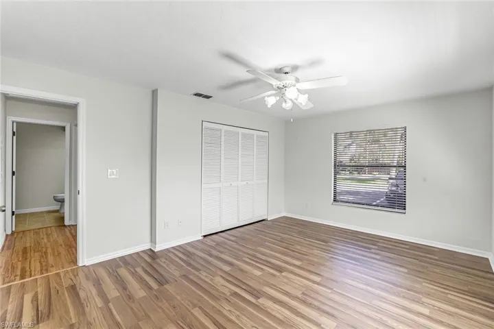 Unfurnished bedroom featuring light wood-style flooring, a closet, baseboards, and a ceiling fan