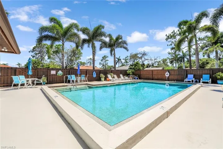 Community pool with fence and a patio area