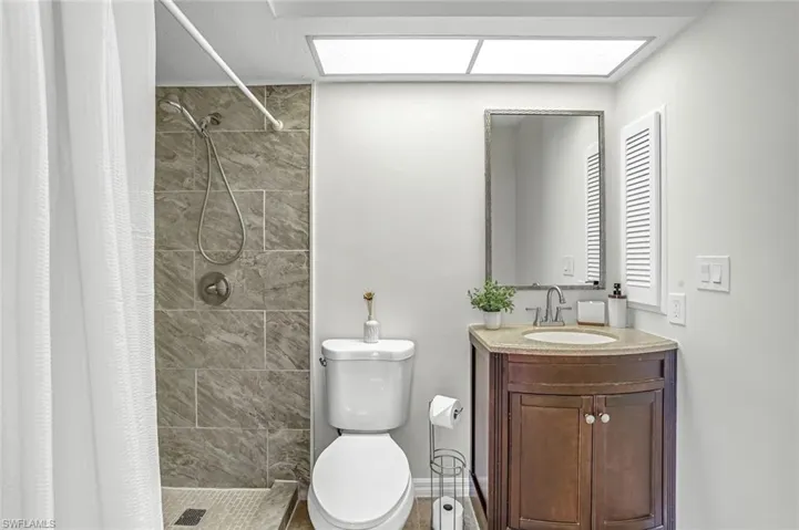 Bathroom featuring a stall shower, toilet, and vanity