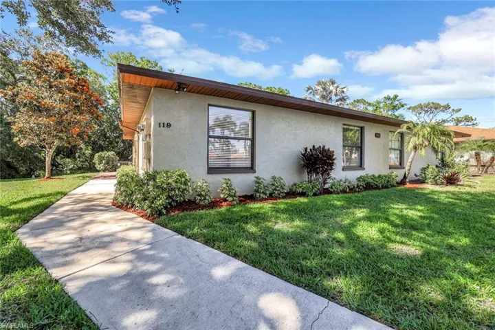 Mid-century inspired home featuring stucco siding and a front yard