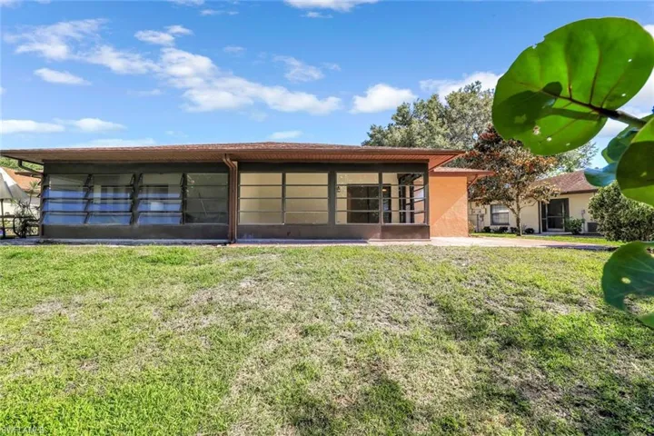 Rear view of property with a lawn