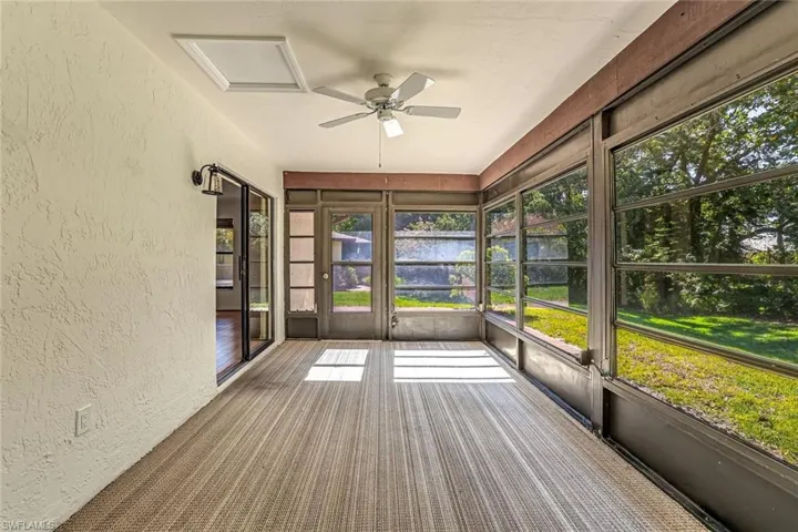 Unfurnished sunroom with a water view, a ceiling fan, and healthy amount of natural light