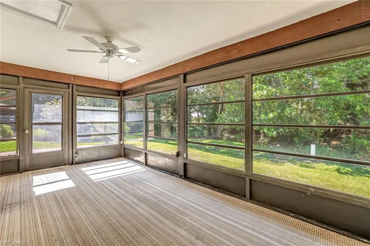 Unfurnished sunroom featuring a ceiling fan