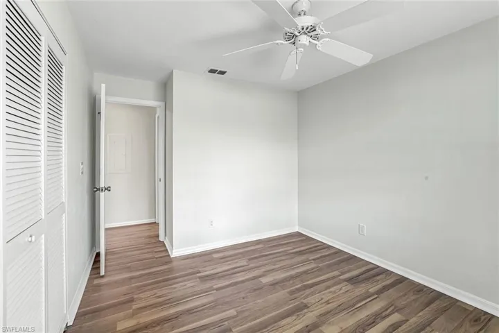 Unfurnished bedroom with wood finished floors, baseboards, a closet, and ceiling fan