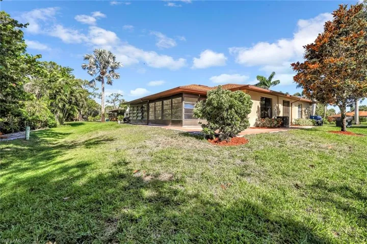 View of grassy yard with a sunroom