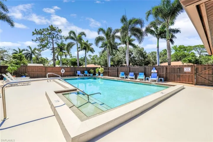 Community pool featuring a patio and fence