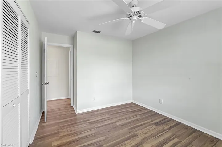 Unfurnished bedroom with wood finished floors, baseboards, a closet, and ceiling fan