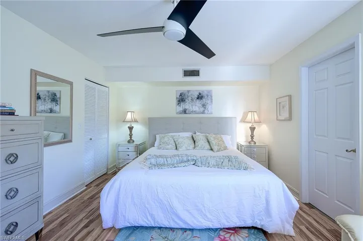 Bedroom with ceiling fan, a closet, and light hardwood / wood-style flooring