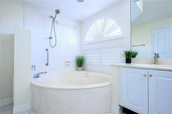 Bathroom featuring vanity and separate shower and tub
