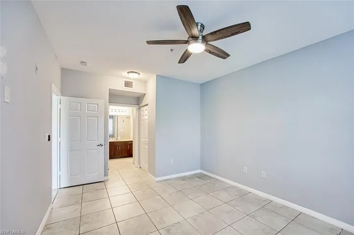 Unfurnished bedroom with ceiling fan and light tile patterned flooring
