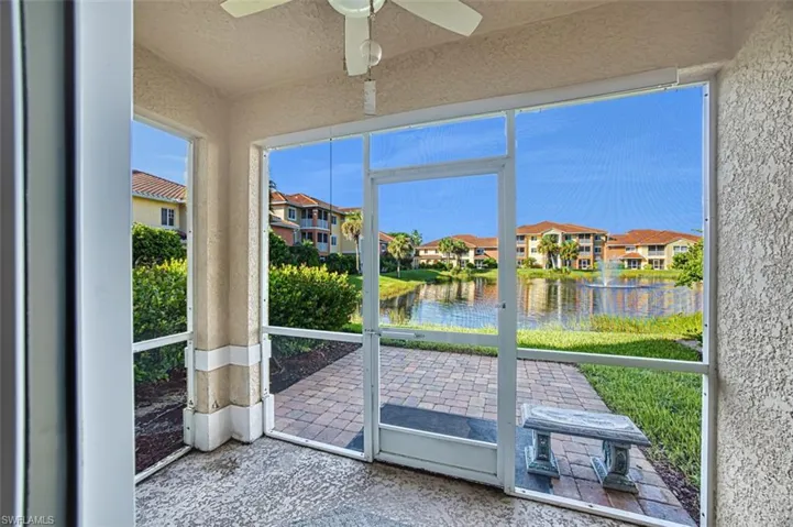 Unfurnished sunroom featuring ceiling fan and a water view