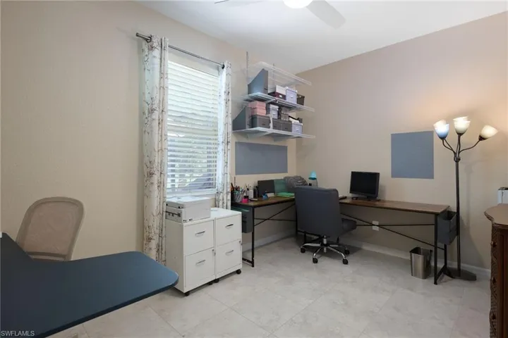 Tiled office space featuring ceiling fan