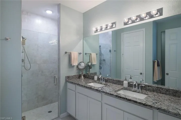 Bathroom featuring walk in shower and double sink vanity