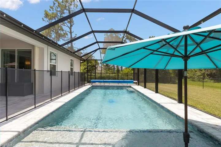 View of swimming pool with a yard and a lanai