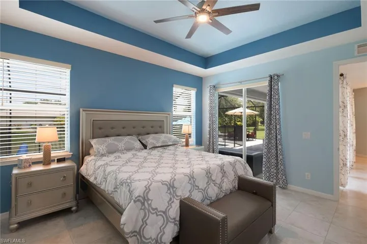 Bedroom with light tile patterned flooring, access to exterior, and ceiling fan