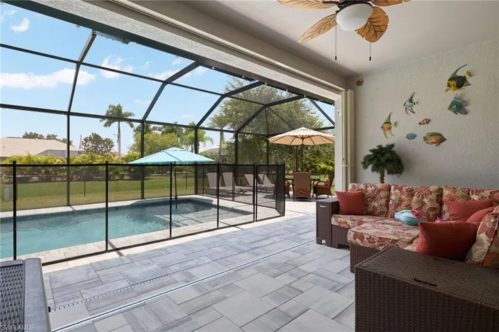 View of pool featuring a lanai, a patio area, and ceiling fan