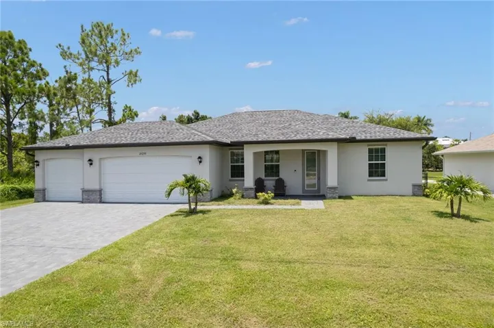 Ranch-style house featuring a garage, central AC, and a front yard