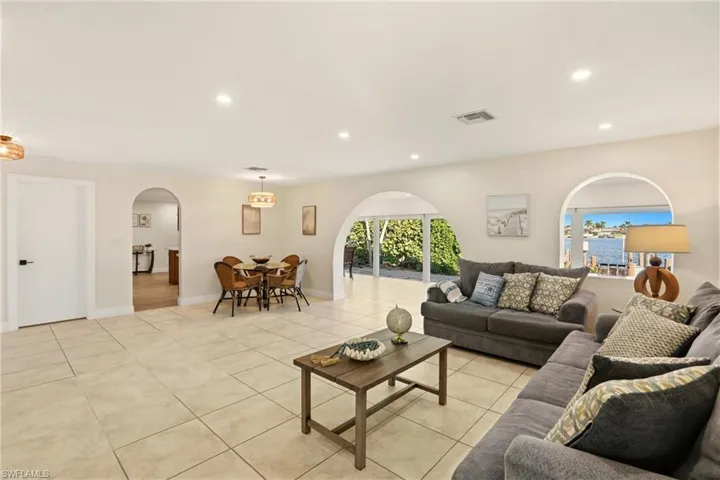 Living area featuring arched walkways, recessed lighting, and light tile patterned floors