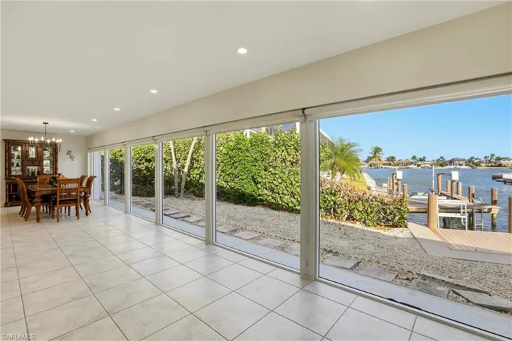 Sunroom / solarium featuring a water view and a chandelier