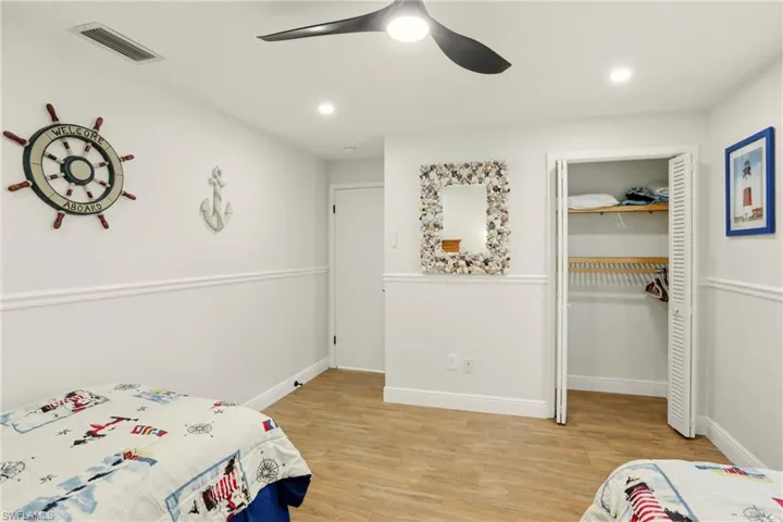 Bedroom featuring light wood-type flooring, a closet, ceiling fan, and recessed lighting
