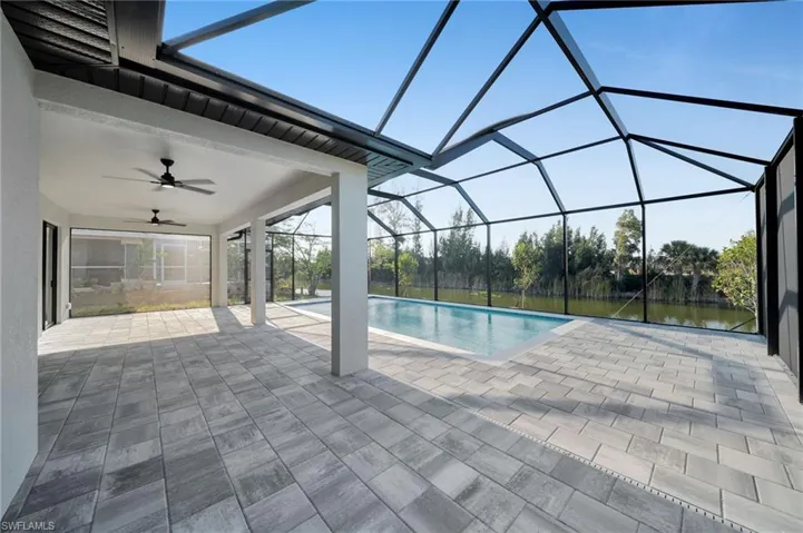 Outdoor pool featuring a lanai, a patio area, ceiling fan, and a sunroom