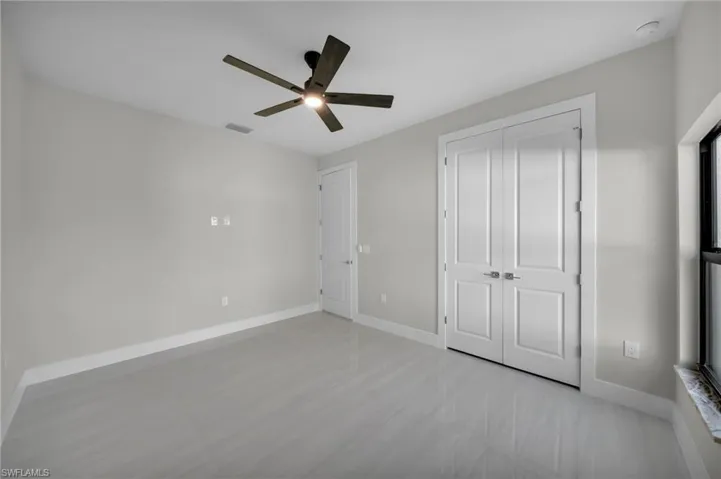Unfurnished bedroom featuring a ceiling fan and a closet