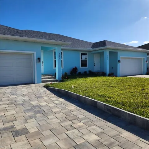 Ranch-style home with an attached garage, a front yard, driveway, and stucco siding