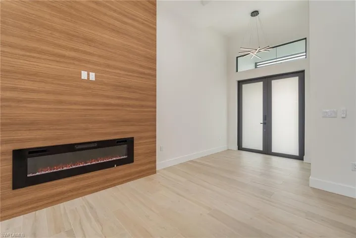 Entryway with french doors, light hardwood / wood-style flooring, and a notable chandelier