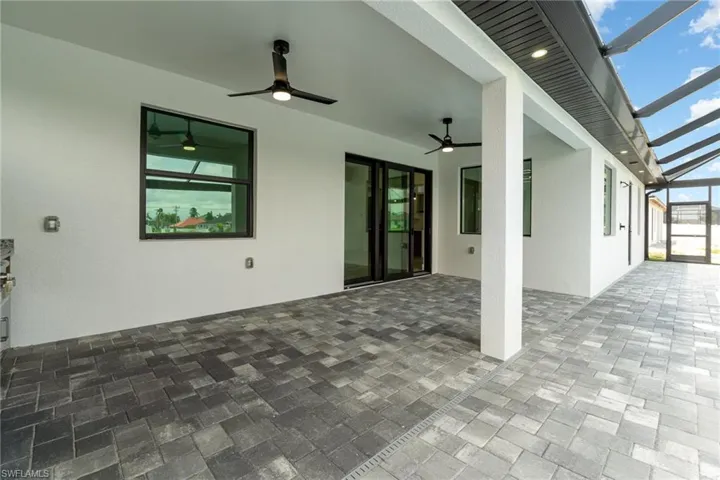View of patio with ceiling fan and glass enclosure