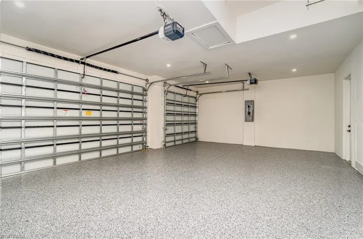 Garage featuring electric panel and a garage door opener