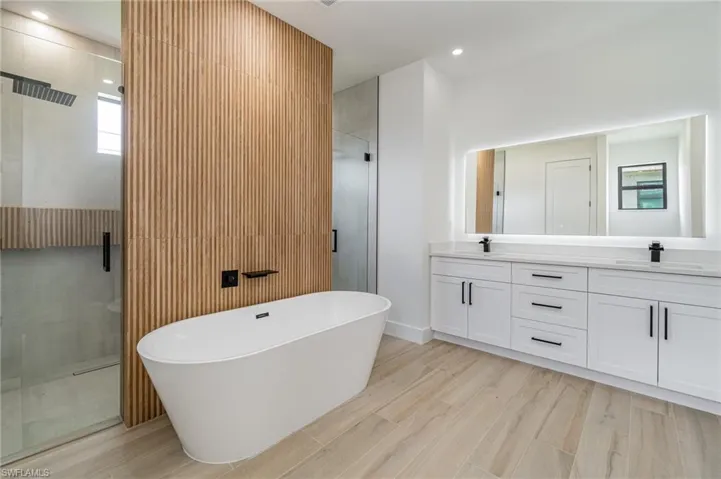 Bathroom featuring plus walk in shower and dual bowl vanity