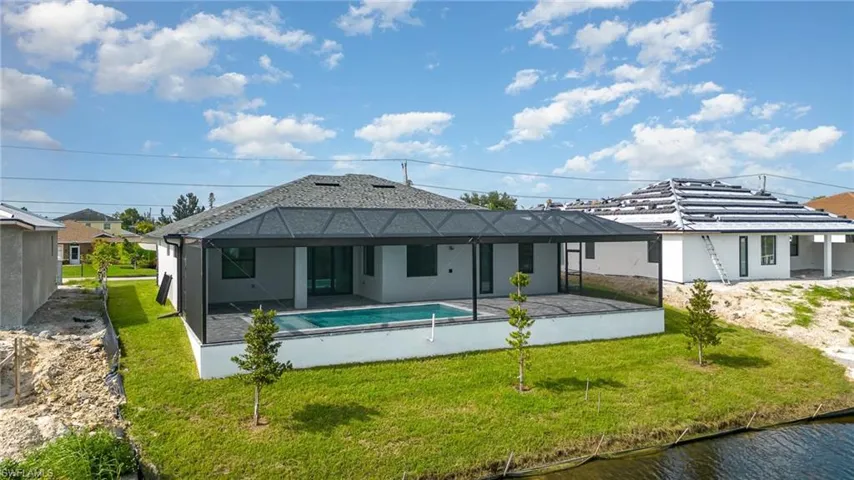 Back of property featuring a lawn and a patio