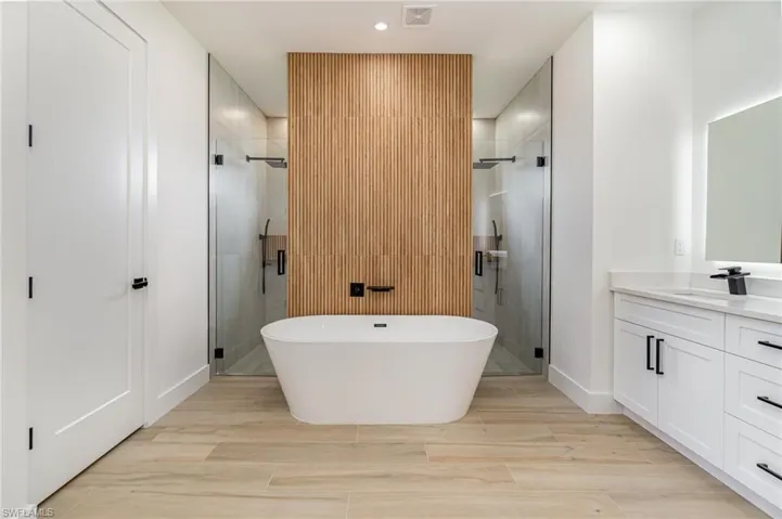 Bathroom featuring vanity and shower with separate bathtub