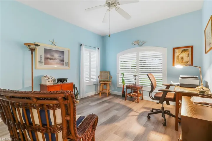 Office space with light wood finished floors and a ceiling fan