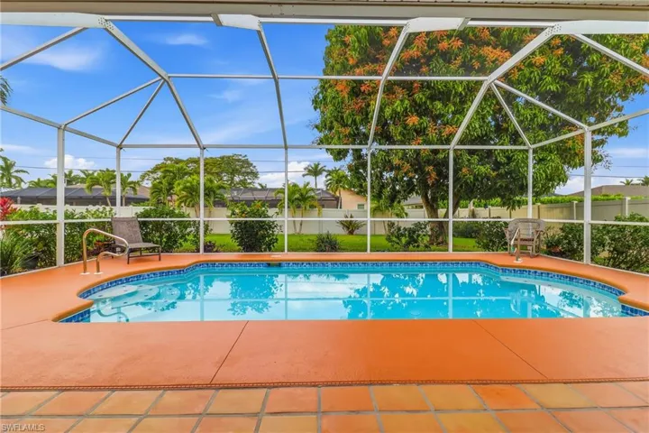View of pool featuring a sunroom and glass enclosure