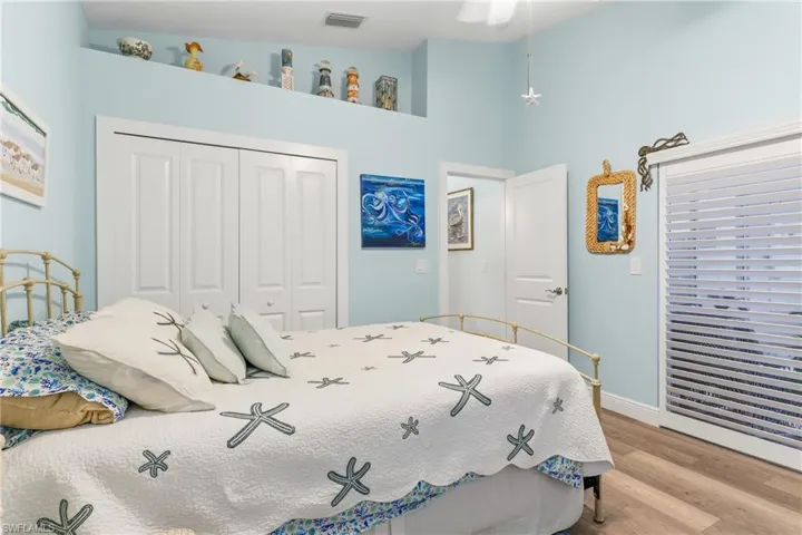 Bedroom with wood finished floors, a closet, and ceiling fan