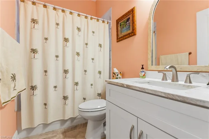 Bathroom featuring vanity, light tile patterned floors, and shower / bath combo