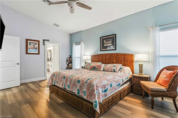 Bedroom featuring hardwood / wood-style flooring, a ceiling fan, and connected bathroom