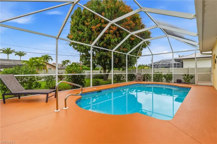 View of swimming pool featuring a lanai, a sunroom, and a patio