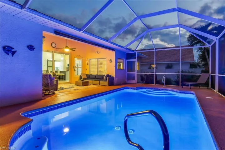 Swimming pool with a sunroom, screen enclosure, an outdoor hangout area, and a patio area