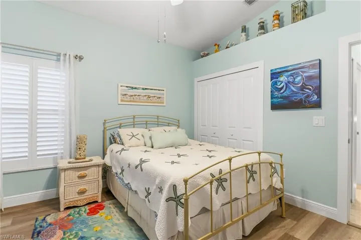 Bedroom featuring lofted ceiling, a closet, and wood finished floors