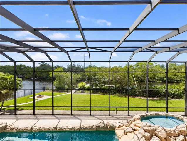 View of pool, backyard, and creek from balcony.