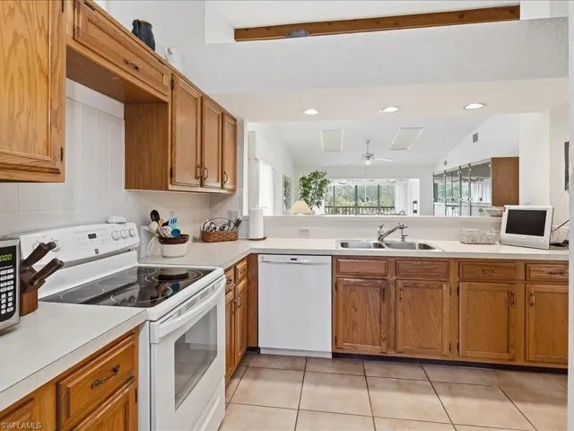 The kitchen has Kenmore appliances, oak cabinetry and tile floors along with double stainless steel sink.